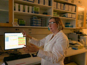 Emily Martin, associate professor of epidemiology and co-director of the Michigan Influenza Center at U-M's School of Public Health, explains how tests are processed at the center's lab in February 2020. The center is part of the U.S. Influenza Vaccine Effectiveness Network run by the Center for Disease Control. 